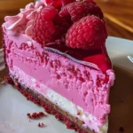 Luxurious pink velvet raspberry cheesecake dessert with swirls and fresh raspberries.