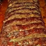 Delicious homemade meatloaf served on a plate with garnished vegetables
