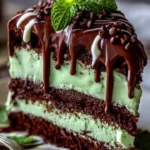 Slice of mint chocolate cheesecake on a plate, garnished with chocolate shavings.