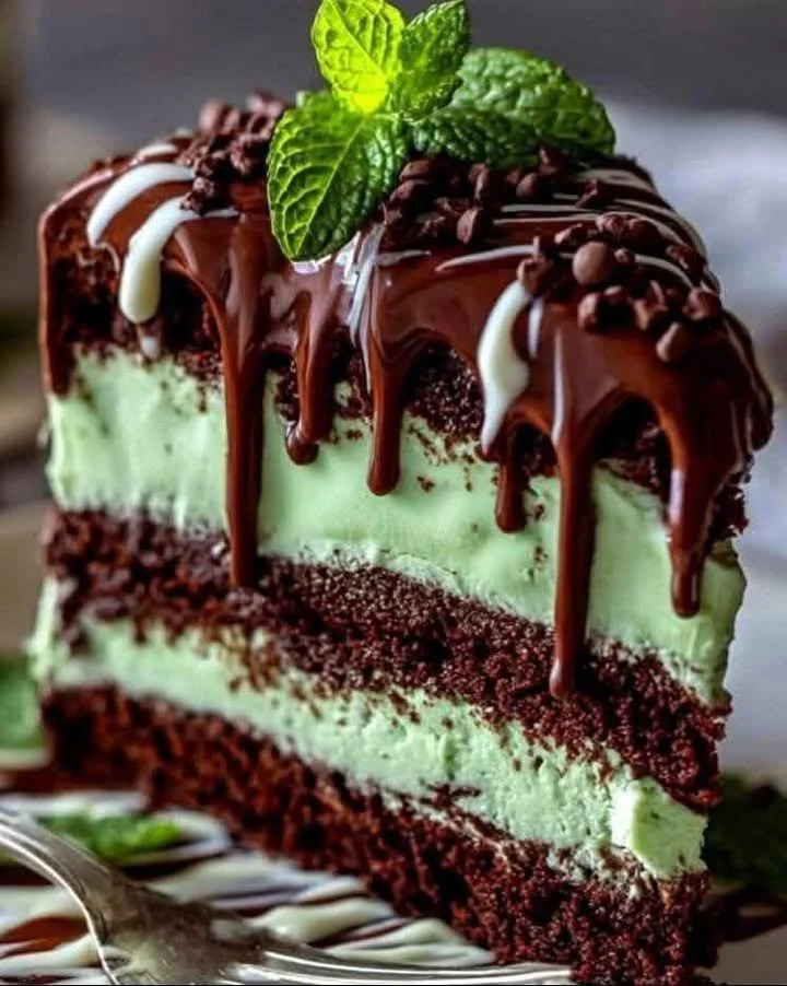 Slice of mint chocolate cheesecake on a plate, garnished with chocolate shavings.