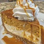 Delicious Pumpkin Caramel Cheesecake topped with caramel drizzle and pumpkin spice.