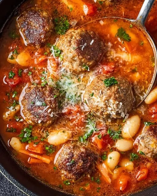 Bowl of rustic Parmesan meatball soup with white beans and tomatoes