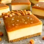 Delicious salted caramel cheesecake bars topped with caramel drizzle.
