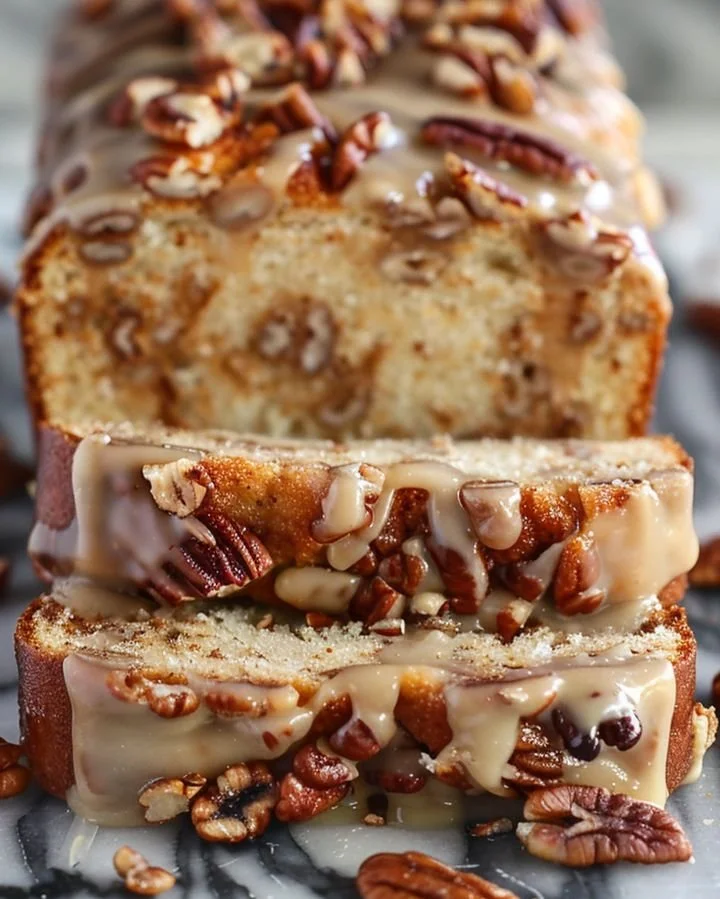 Slice of Southern Pecan Praline Buttermilk Cake topped with pecans and praline glaze
