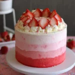 Strawberry ombre cake with beautiful gradient layers and fresh strawberries on top.
