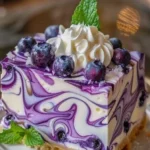 Delicious white chocolate blueberry cheesecake slice with fresh blueberries on top.