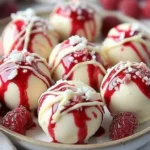 White chocolate raspberry cheesecake balls garnished with fresh raspberries