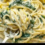 Zesty lemon ricotta and spinach pasta served in a bowl topped with fresh herbs.