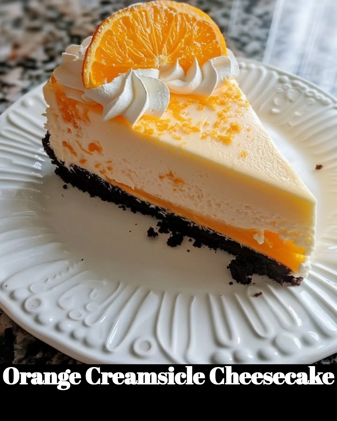 Slice of orange creamsicle cheesecake on a plate with a garnish.