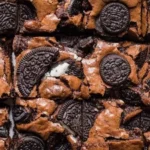Delicious Oreo Brownies topped with cookie crumbles and chocolate drizzle