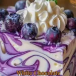 Slice of white chocolate blueberry cheesecake topped with fresh blueberries