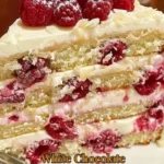 Delicious White Chocolate Raspberry Cake topped with fresh raspberries