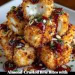 Almond-Crusted Brie Bites drizzled with cranberry honey glaze on a platter.