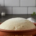 Homemade artisan pizza dough ready for baking with fresh ingredients.
