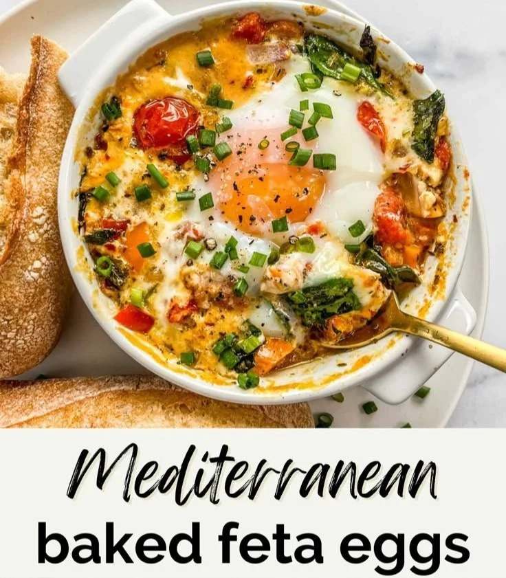 Baked feta eggs with tomatoes and spinach in a skillet