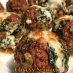 Cheesy spinach garlic meatballs served on a plate, garnished with herbs.