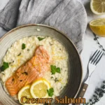 Delicious creamy salmon risotto garnished with herbs in a white bowl