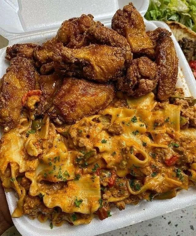 Crispy fried chicken wings served with cheesy lasagna on a plate