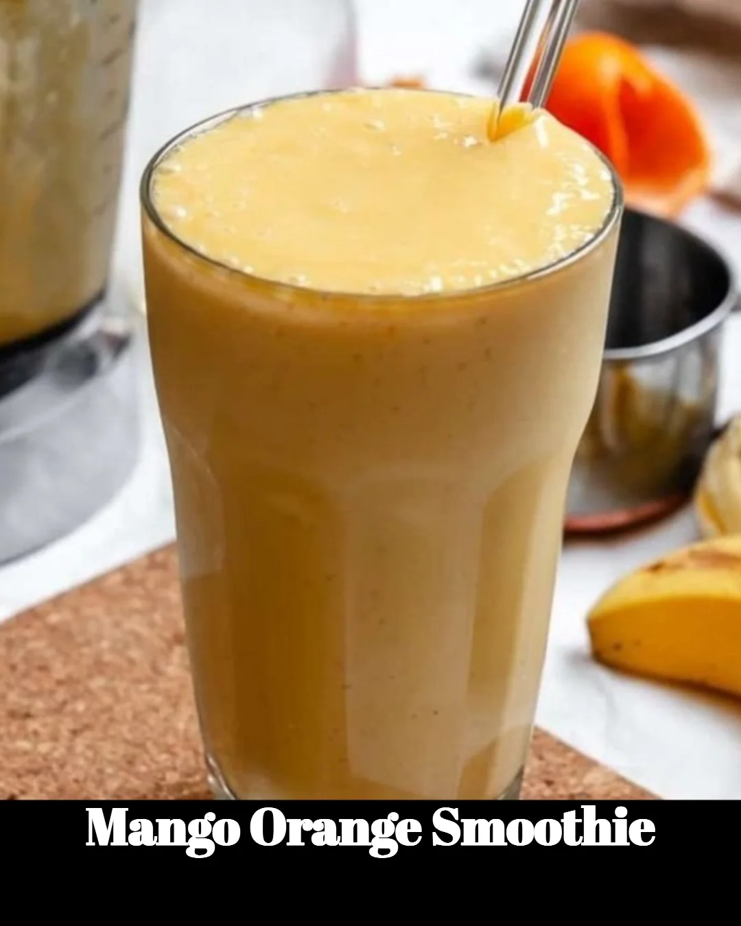 A refreshing mango orange smoothie in a glass garnished with fresh fruit.