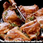 Delicious pan roasted rabbit served with wine and garlic sauce on a plate.