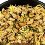 Pasta and mussels in creamy white wine sauce served in a bowl