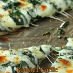 Roasted garlic spinach white pizza topped with fresh spinach and mozzarella cheese.