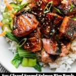 Delicious soy-glazed seared salmon rice bowl topped with fresh vegetables.