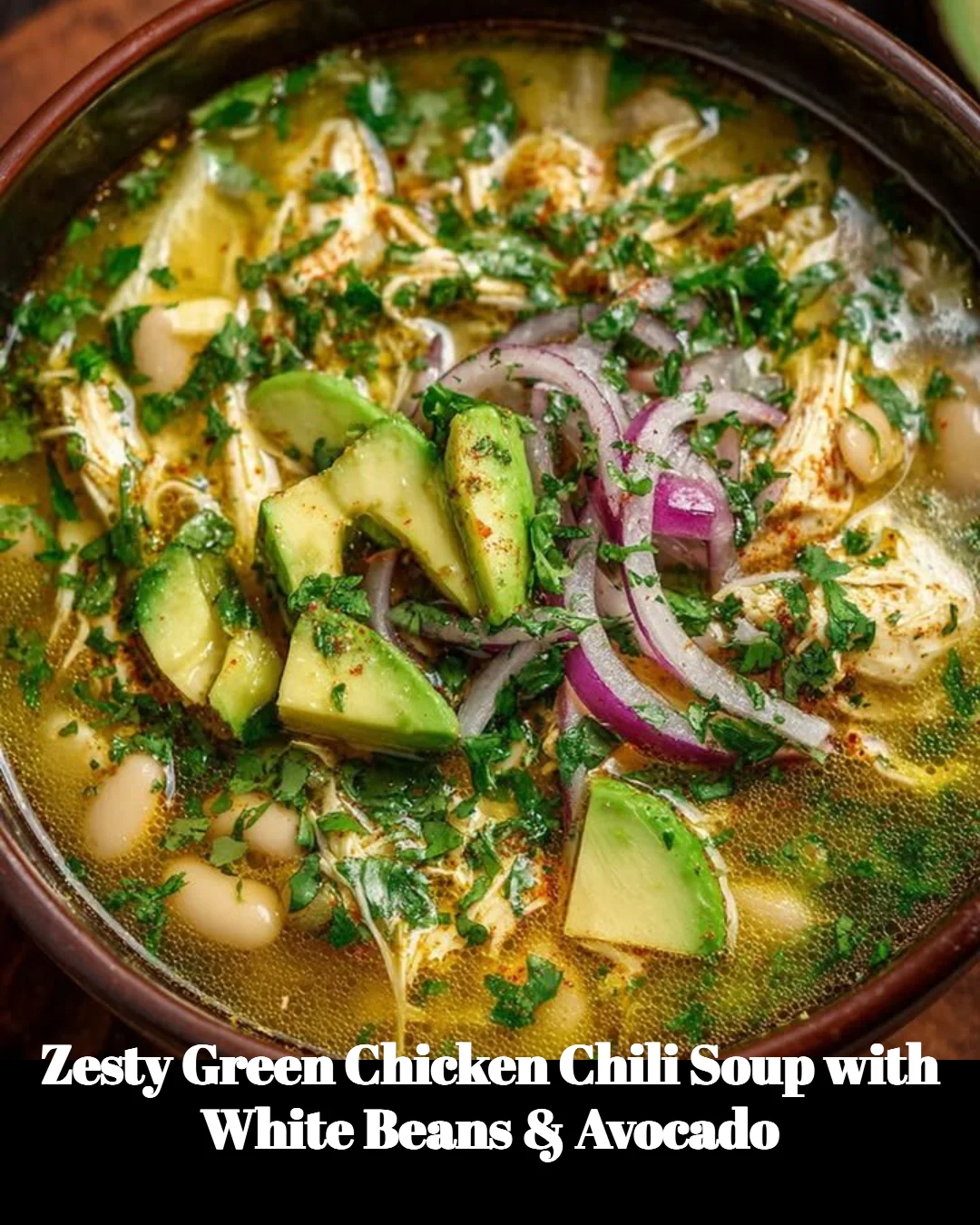Zesty green chicken chili soup with white beans and avocado in a bowl.