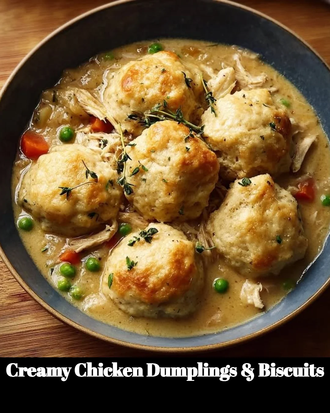 Creamy chicken dumplings and biscuits in a bowl, garnished with herbs.