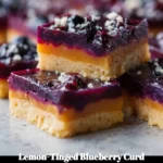 Blueberry curd shortbread bars with lemon zest on a plate