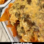 Plate of delicious loaded nachos topped with cheese and jalapeños