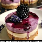 Mini blackberry lavender cheesecakes topped with fresh blackberries and lavender sprigs.