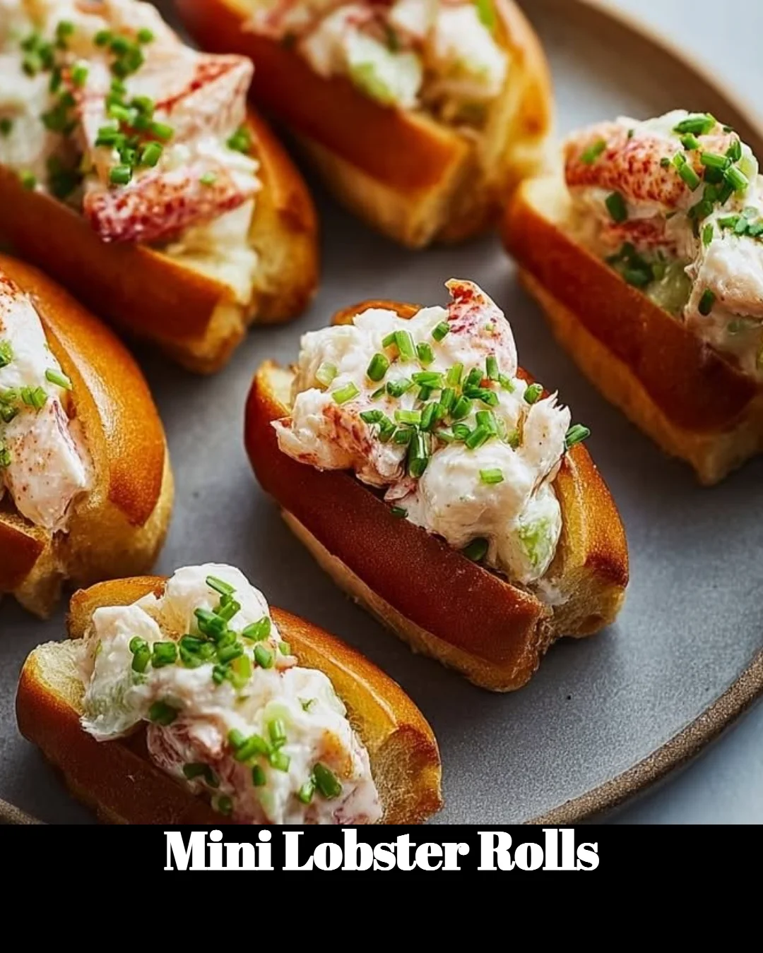 A plate of delicious mini lobster rolls garnished with herbs.