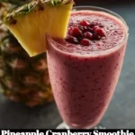 Delicious pineapple cranberry smoothie in a glass with fresh fruits