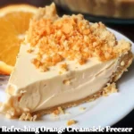 Refreshing orange creamsicle freezer pie topped with whipped cream and orange slices.