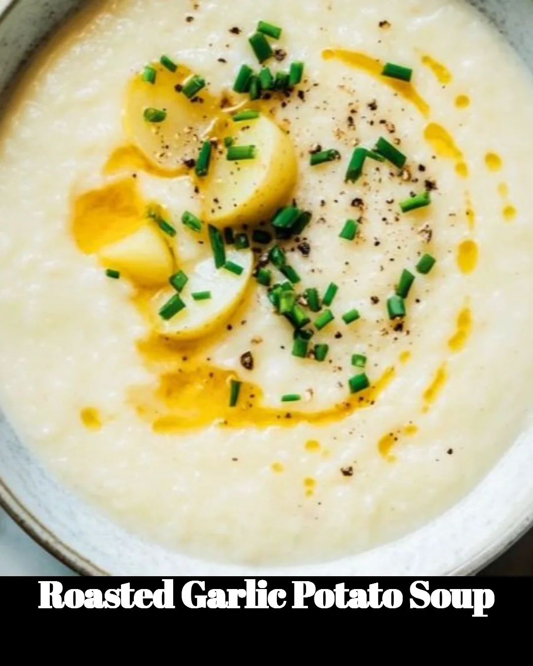 Delicious bowl of roasted garlic potato soup served with fresh herbs