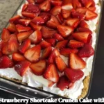 Strawberry Shortcake Crunch Cake with cream cheese frosting on a rustic table
