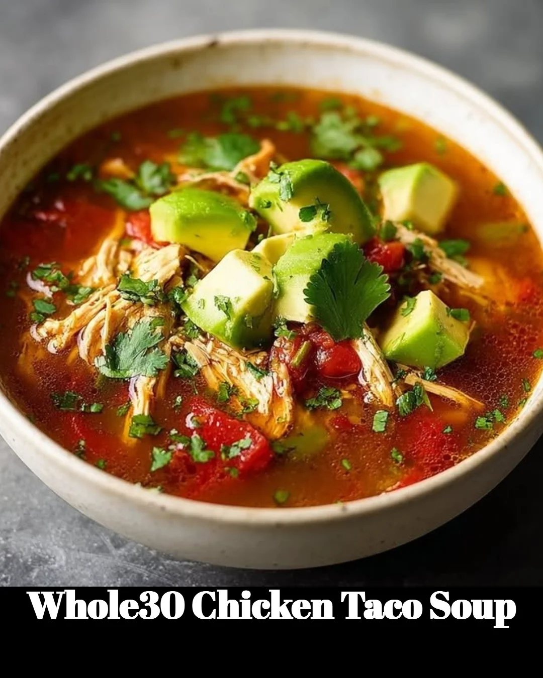 Bowl of Whole30 Chicken Taco Soup topped with avocado and cilantro.