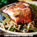 Asian salmon dish featuring noodles, mushrooms, and snap peas