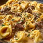 A delicious plate of Beef Parmesan Tortellini topped with cheese and herbs.