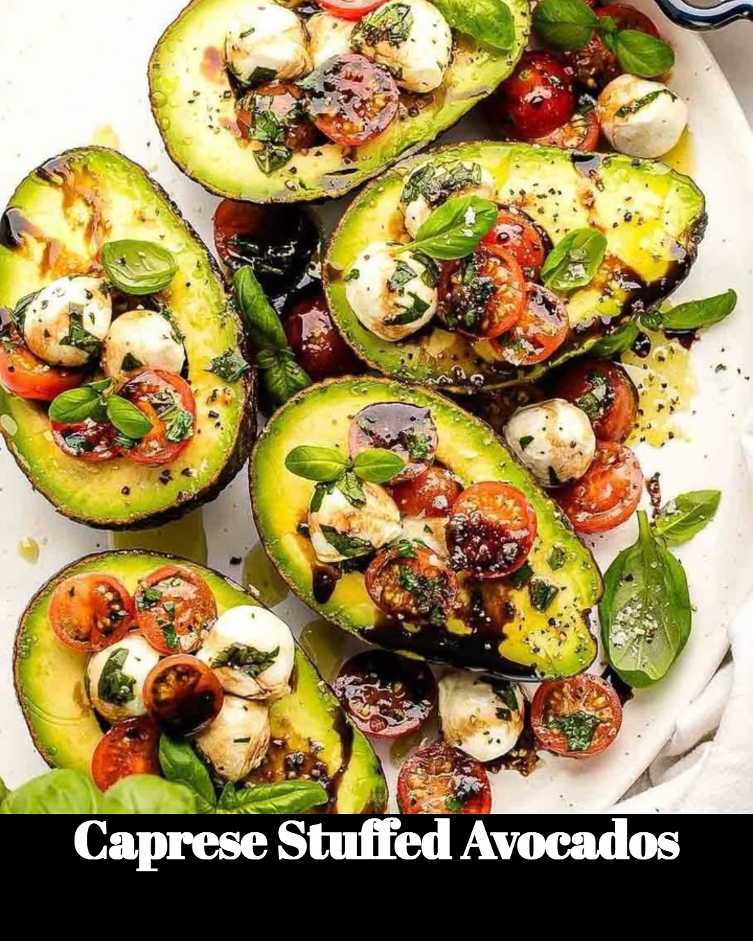 Caprese stuffed avocados with fresh tomatoes, mozzarella, and basil garnish