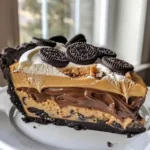 Delicious Chocolate Peanut Butter Pie topped with chocolate drizzle and peanut butter cups