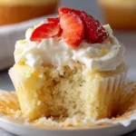 Delicious easy tres leches cupcakes topped with whipped cream and strawberries.