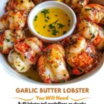 Garlic butter lobster bites served on a platter with herbs.