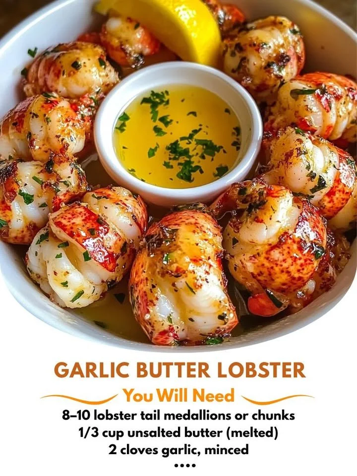 Garlic butter lobster bites served on a platter with herbs.