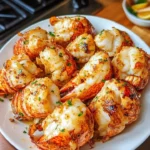 Delicious garlic butter lobster tails served on a plate with herbs.