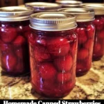 Jar of homemade canned strawberries on a wooden table