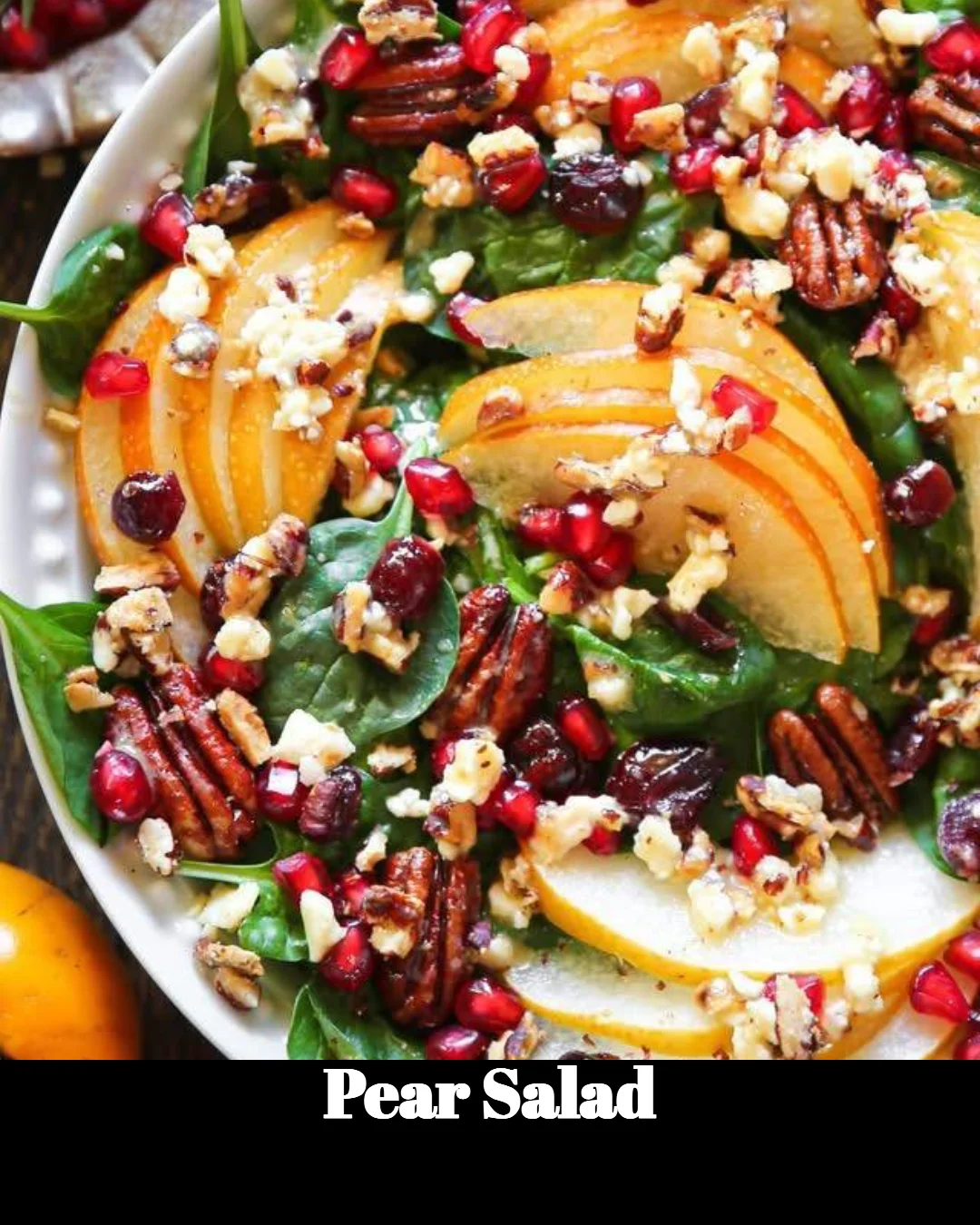 Fresh pear salad with greens and dressing in a bowl.